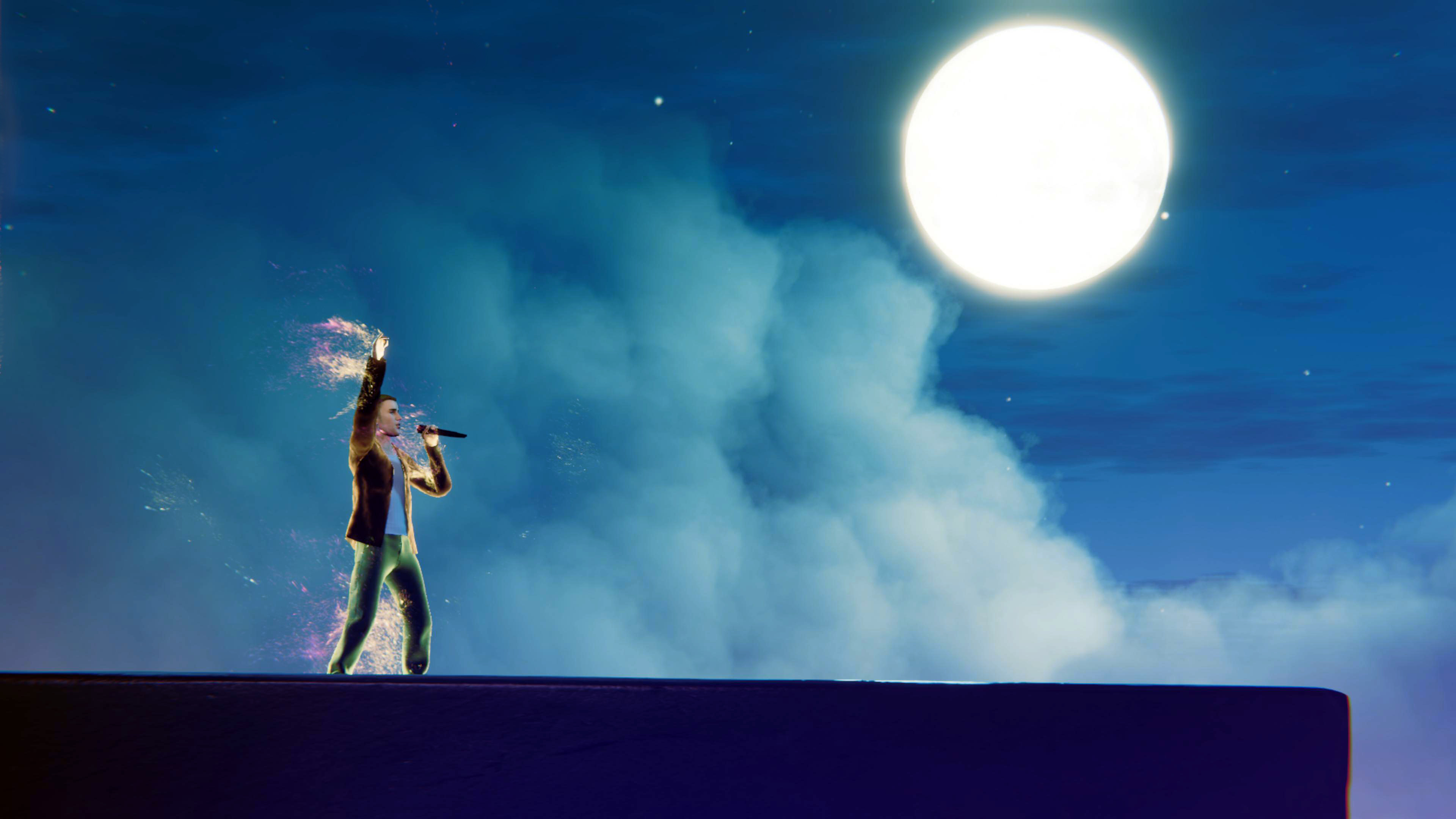 Justin Bieber performing against blue sky with clouds and bright moon